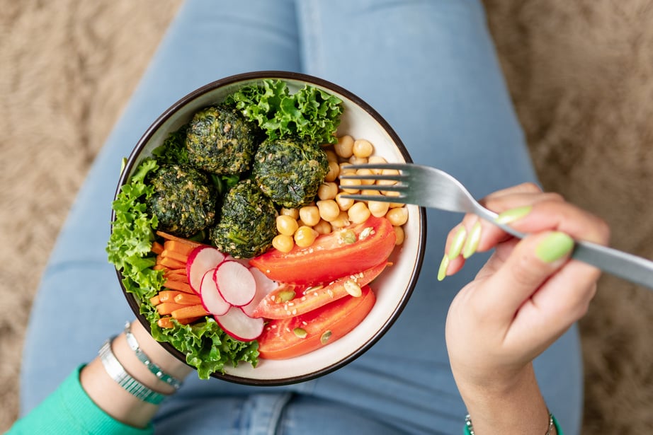 Close up of woman eating delicious vegan food. Plant based, cruelty free food concept